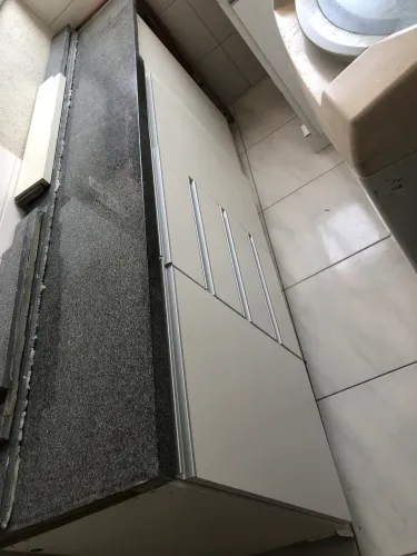 Balcão em MDF para lavanderia com tampo de mármore e pia esculpida