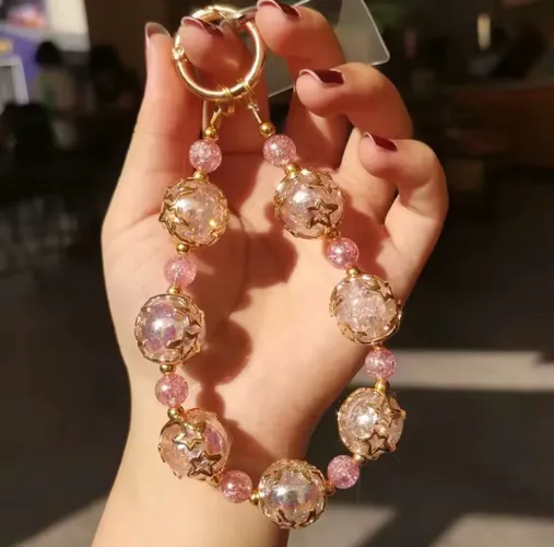 Cordão para celular dourado com pedras rosadas