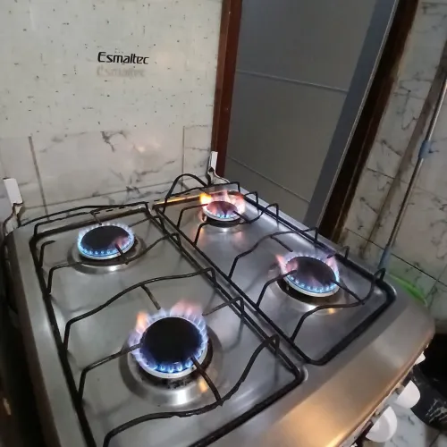 Fogão 4 bocas, com forno elétrico funcionando.