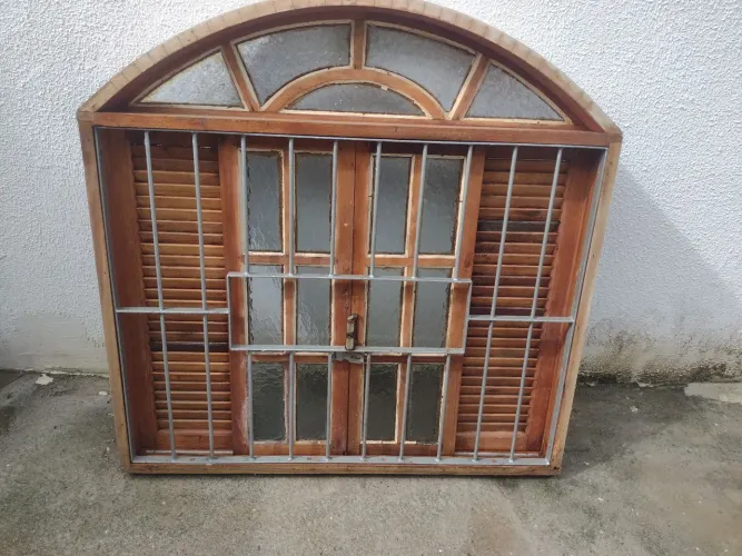 Janela de madeira com grade de proteção.