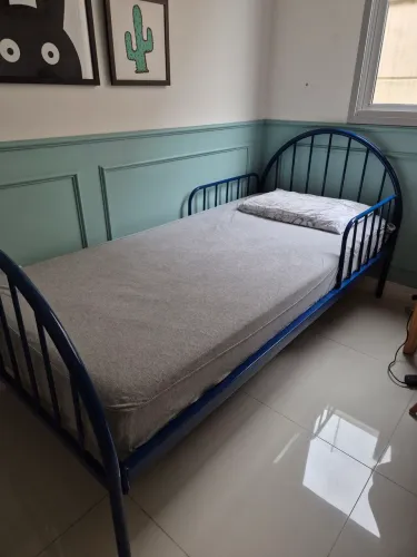 Cama solteiro toda em ferro, incluindo estrados, com proteção fixa nas bordas.
