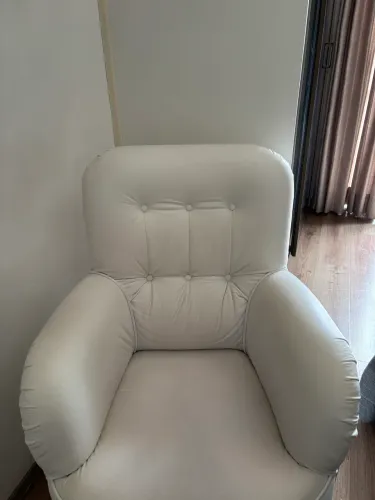 Poltrona em couro branco para amamentação.