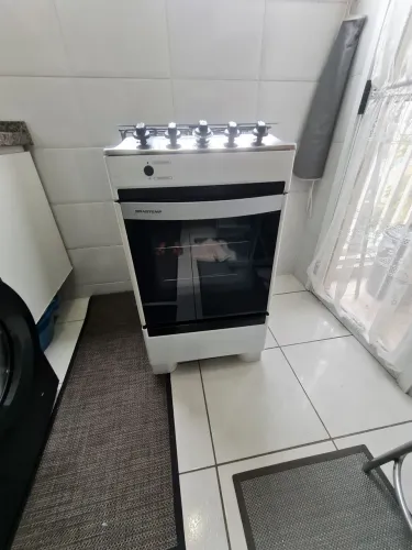 Fogão Brastemp com mesa de inox, tampa de vidro e acendimento automático.