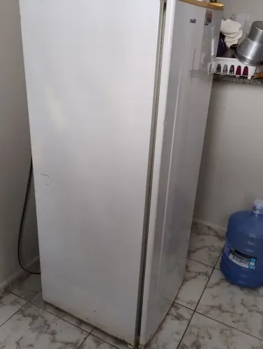 Geladeira, mesa de plástico e escrivaninha