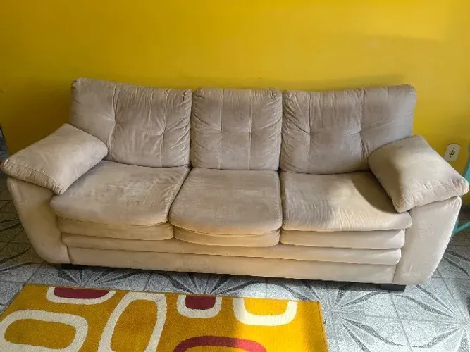Sofá de tecido 3 lugares na cor bege.