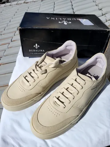 Tênis bege da marca Dudalina apresenta um design casual com detalhes em camurça.
