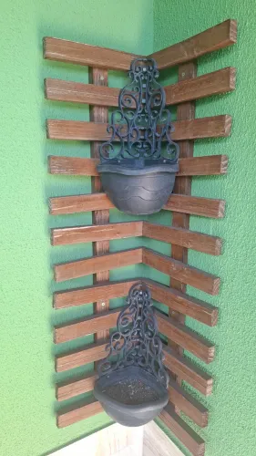 Painel de madeira de canto com dois vasos de plantas
