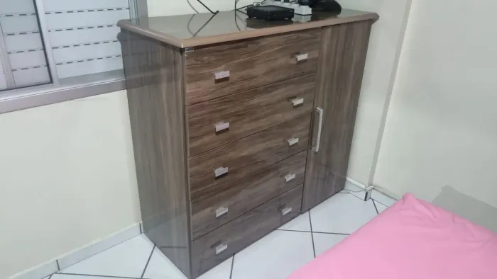Cômoda com 5 gavetas e 1 porta que pode ser usada como sapateira.