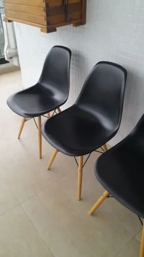 Cadeira preta design com pés de madeira