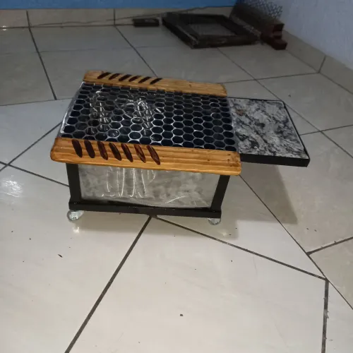 Churrasqueira com rodinhas e tabua pra carne