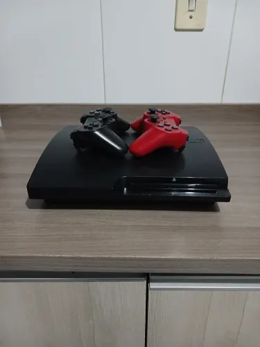 PS3 com dois controles e jogos digitais