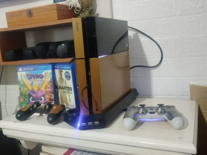 PS4 com dois controles e alguns jogos