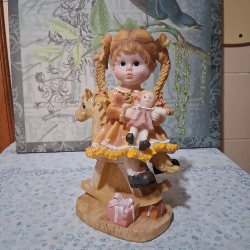 Escultura menina com boneca e cavalinho 21 cm altura.