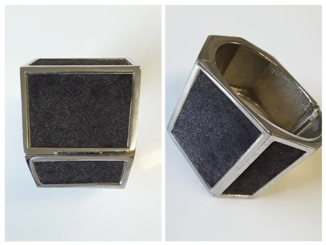 Pulseira de metal prateado e grafite com brilho.