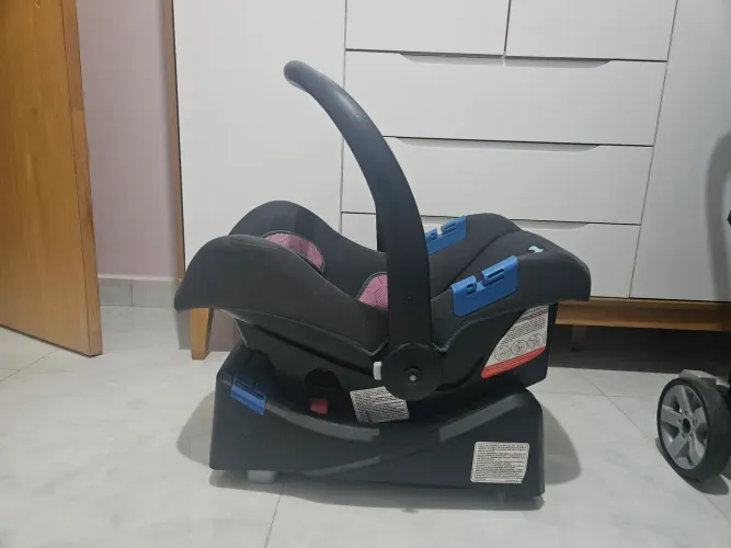 Berço, cadeira de alimentação e carrinho com bebê conforto