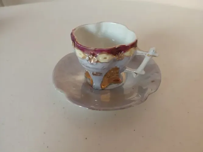 Xícara de cafezinho miniatura antiga em porcelana, com detalhes dourados e pires