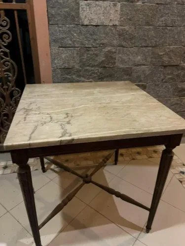 Mesa com tampo de mármore e pés de madeira torneados.