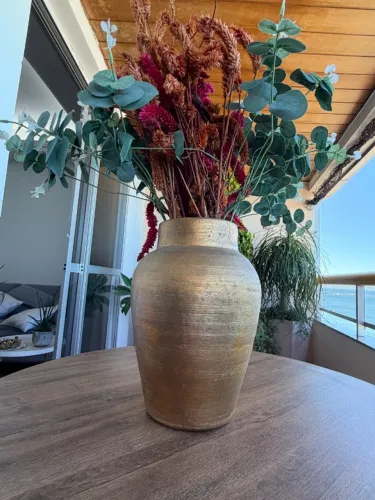 vaso de barro com acabamento dourado, usado para decoração com arranjos secos ou artificia