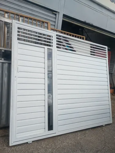 Portão galvanizado medindo 2.10 x 2.60 com detalhe de vidro no portão de pedestre.