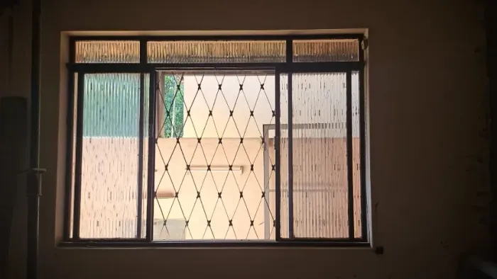 Janela de aço com vidro e grade externa