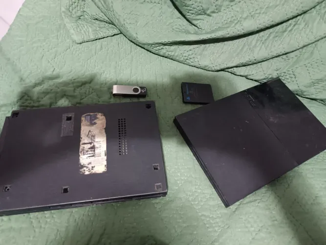 Tampa de play 2 de cima e de baixo com pen drive com dois jogos e um memory card