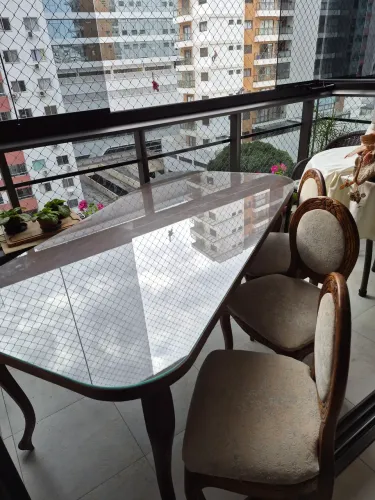 Uma mesa de madeira com tampo de vidro e 6cadeiras