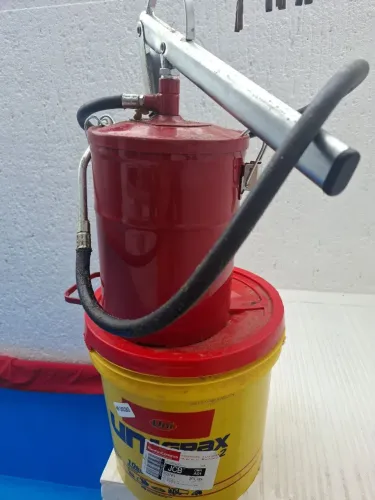 Vendo engraxadeira com um balde de graxa.