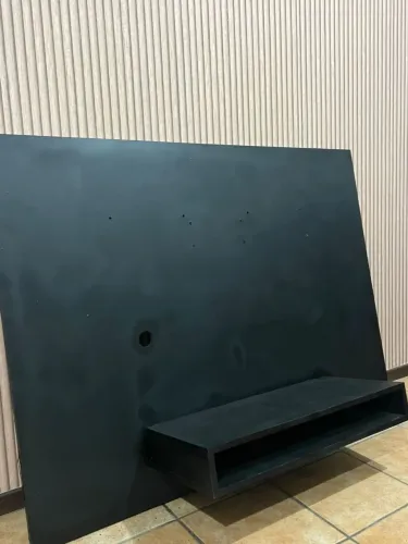 Painel de TV preto, com uma prateleira.