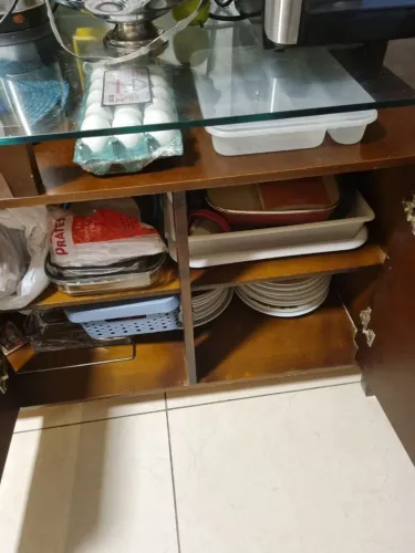 aparador/buffet de madeira com tampo de vidro e portas de armário.