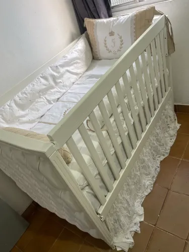 Berço de madeira maciça e capitonê bege
