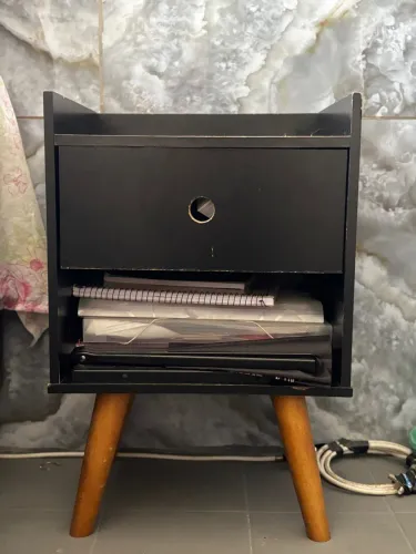 Mesa de cabeceira preta com pés de madeira