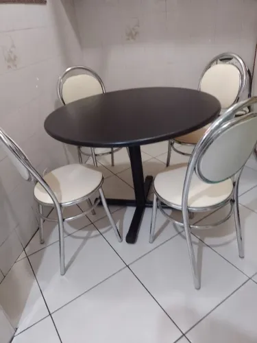 Mesa preta com 4 cadeiras confortáveis em inox .