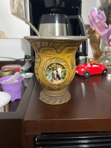 Esta é uma cuia de chimarrão artesanal decorada com temática gaúcha. 