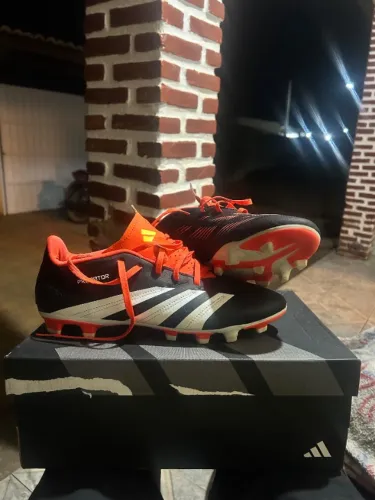 Chuteira predator FXG preto e laranja