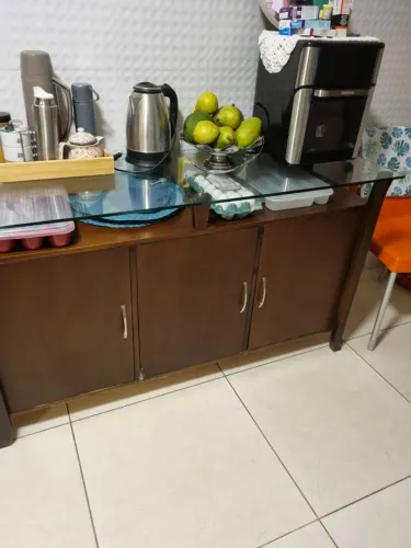 aparador/buffet de madeira com tampo de vidro e portas de armário.