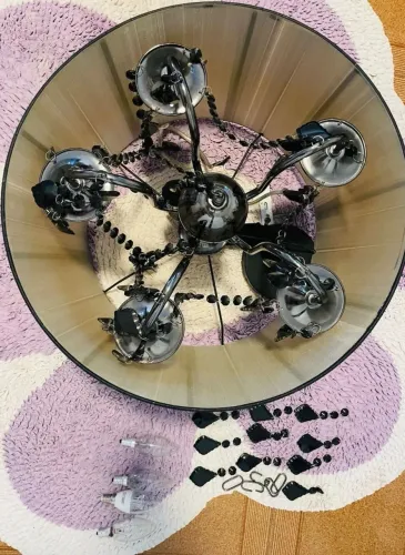 Lustre de 5 braços, com acabamento cromado, cúpulas e detalhes em pedrarias pretas.