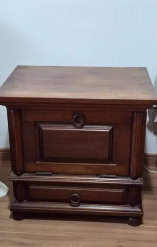 Mesa de cabeceira antiga de madeira maciça com porta rebatível e gaveta