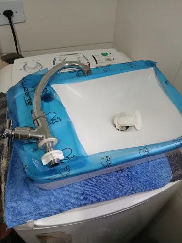 Pia de banheiro quadrada marca luzarte nova no plástico tem uma torneira e uma boca de ral
