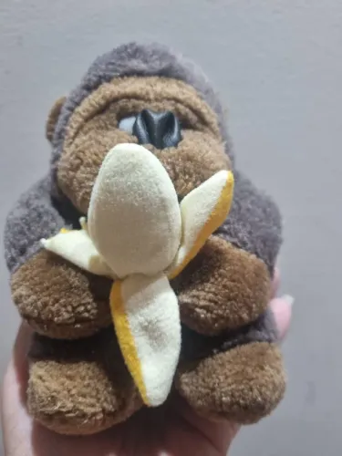 macaco de pelúcia com defeito na banana