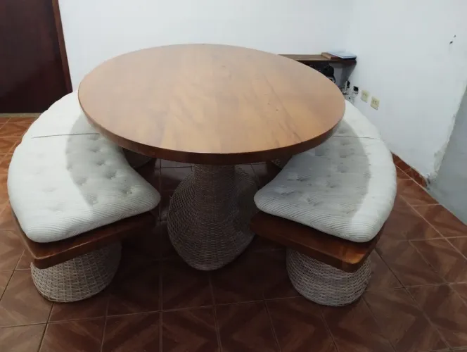 Mesa oval de madeira maciça acompanha dois bancos também de madeira maciça