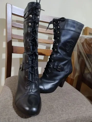 Botas de couro preto, Dokota com salto alto, amarração de cadarço na frente e fivelas.