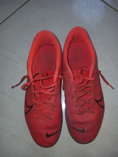 Tênis Futsal Nike Mercurial Vapor 13 Club vermelha com detalhes pretos.