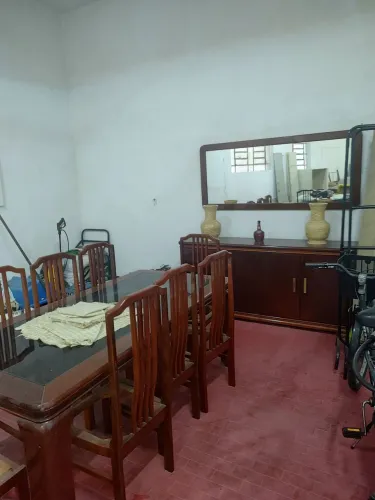 Sala de jantar, composta por mesa de mogno com oito cadeiras, espelho, móvel para louças.