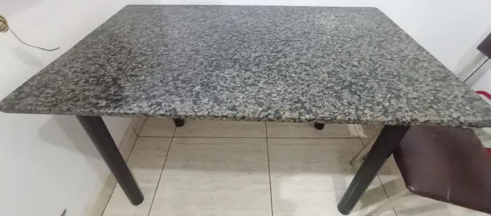 Mesa de mármore com cinco cadeiras.