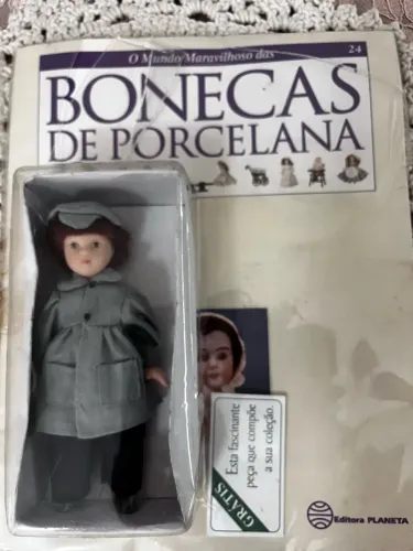Boneca de porcelana antiga com revista