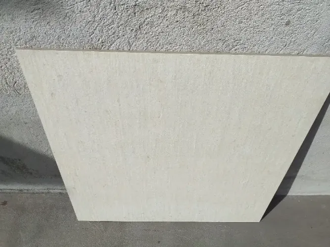 Três caixas de porcelanato retificado BIANCOGRES cor bege claro.