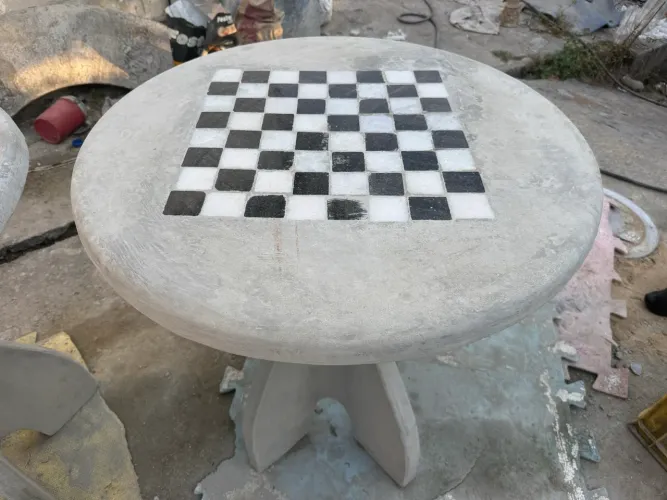 Mesa de concreto com xadrez e 2 bancos curvos