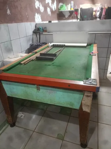 Mesa de sinuca grande de fichas tem os tacos bolinhas