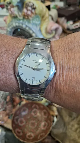 relógio é um Longines Oposition em aço inoxidável com mostrador branco.