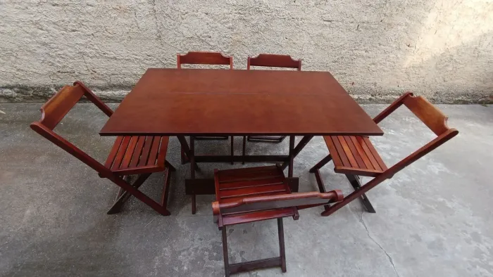 Mesa de madeira dobrável com 5 cadeiras.